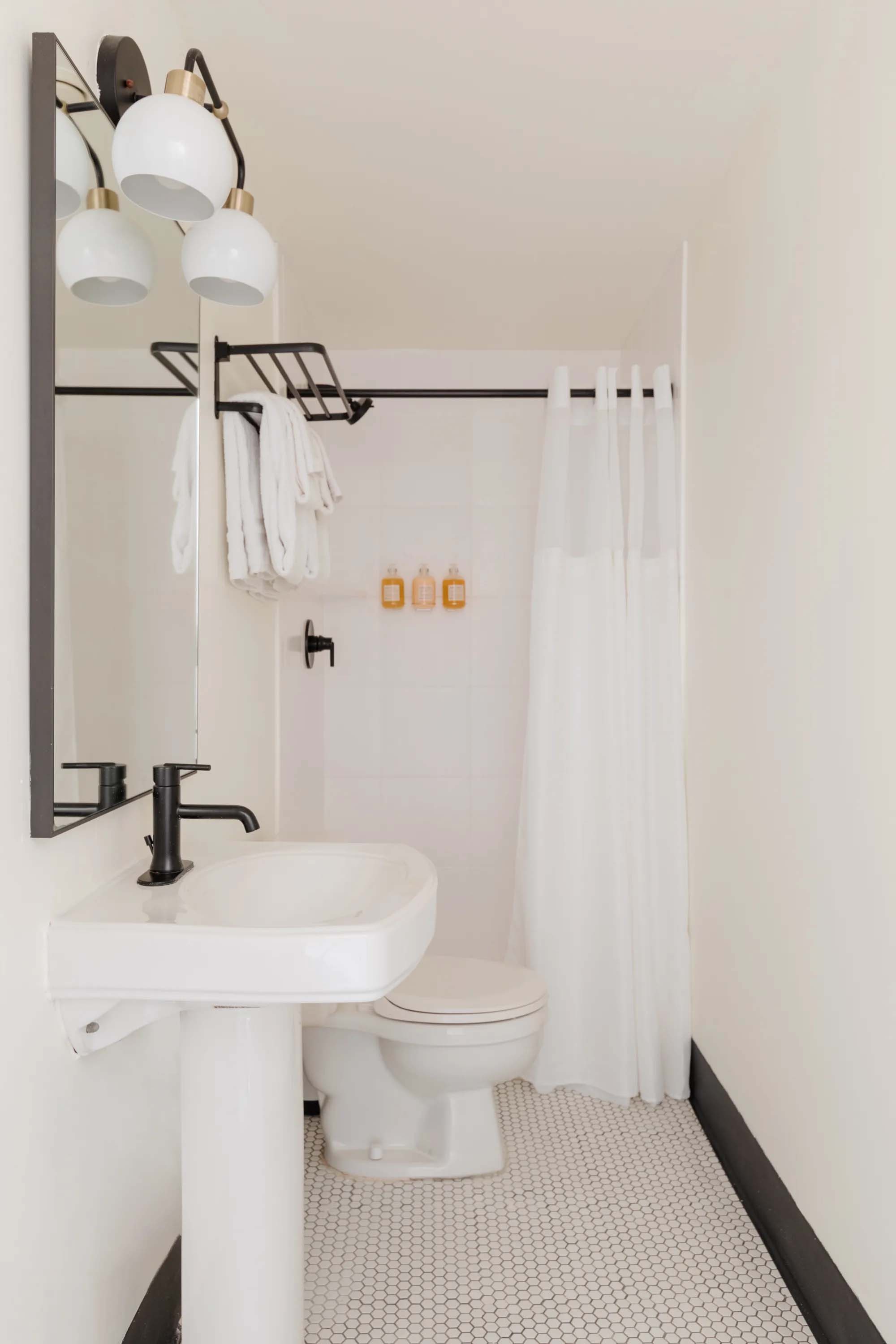A clean and modern bathroom with a white sink, toilet, and shower.